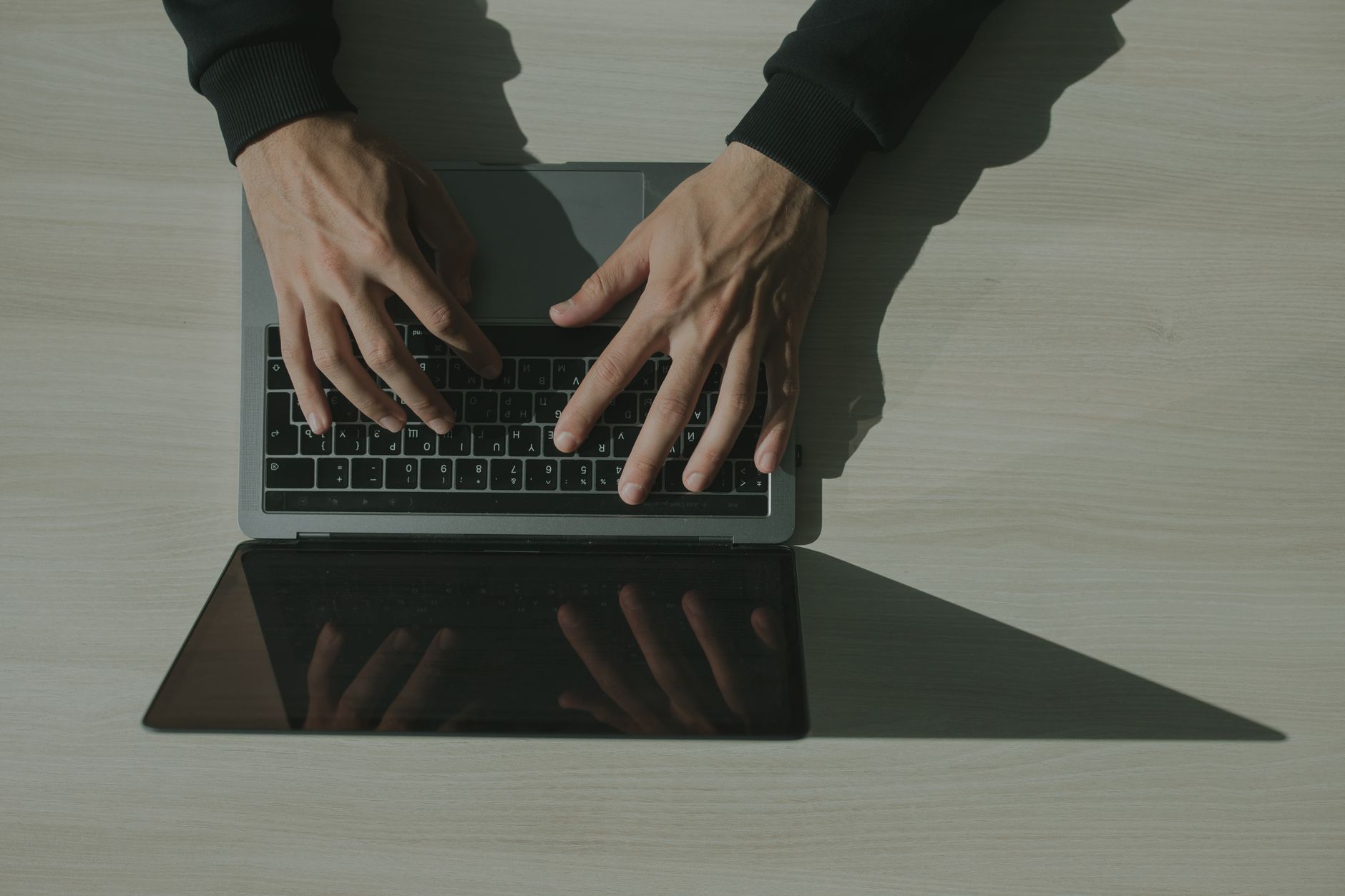Mains sur le clavier d’un ordinateur portable vu du dessus
