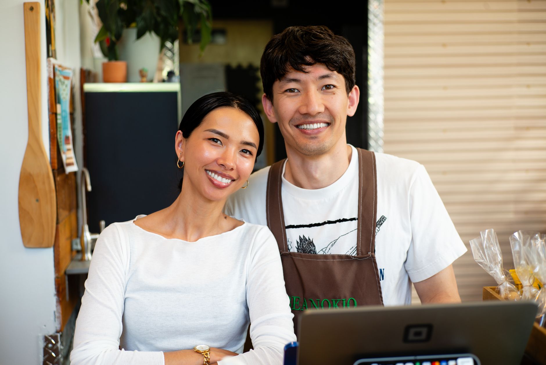 Deux commerçants souriants derrière leur comptoir