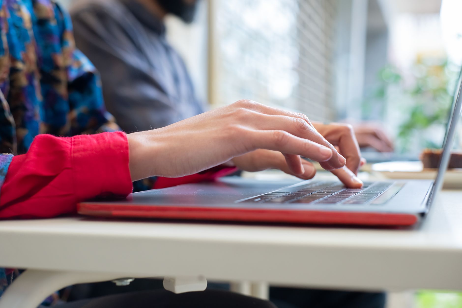 Personne qui rédige un courriel à son bureau