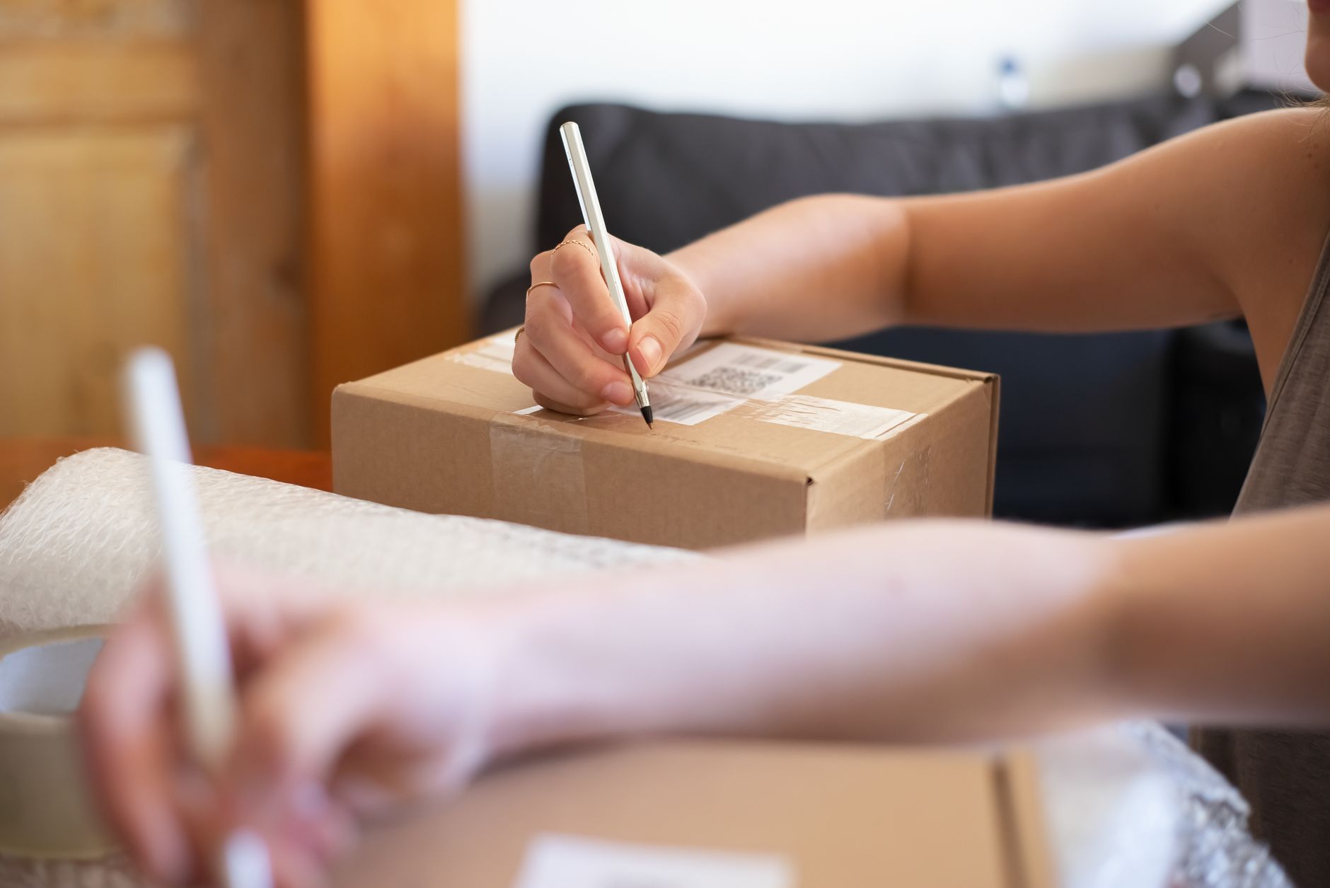 Mains collant une étiquette d’expédition sur un carton