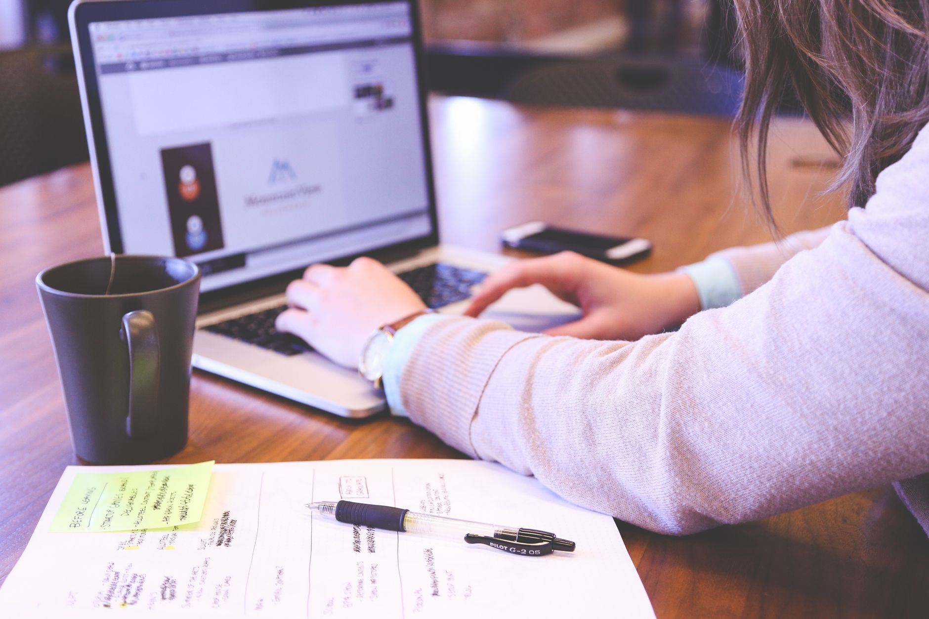 Professionnelle qui tape sur son ordinateur avec des notes