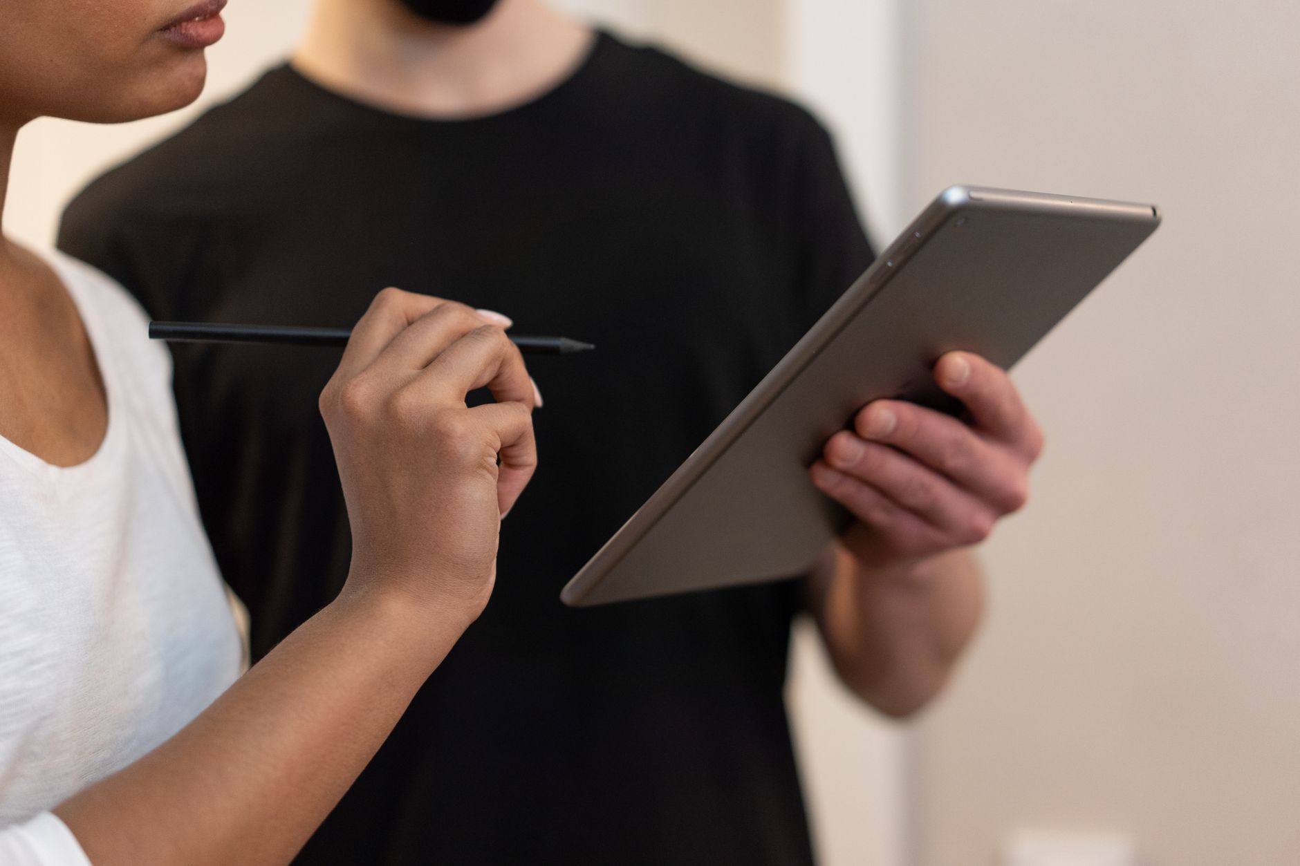 Deux collègues signent sur une tablette avec un stylet